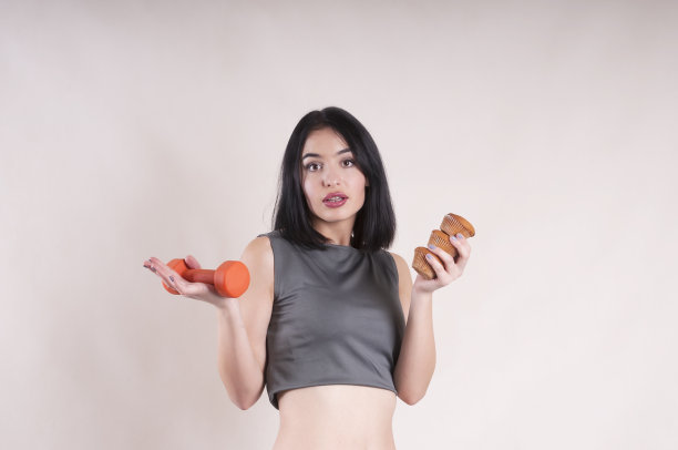 带着蛋糕和哑铃的漂亮运动女孩图片下载