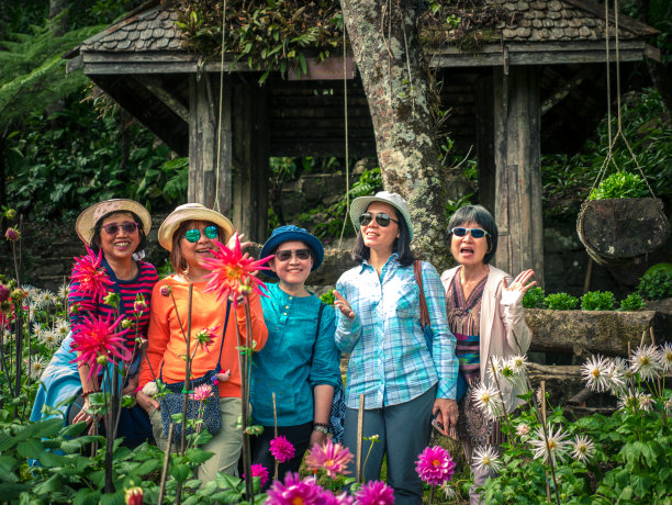 亚洲女性朋友在中年有乐趣旅游和拍照一起在鲜花花园在泰国钦格雷图片下载