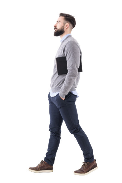 自信严肃的商人走路时，腋下夹着计划表。侧视图。图片下载