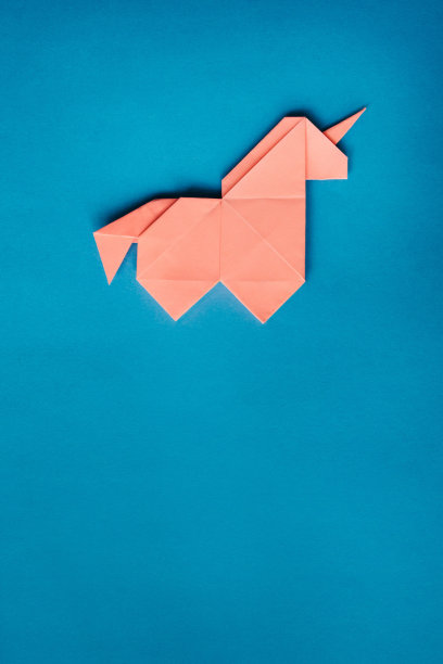 蓝色背景上的粉色折纸独角兽图片下载