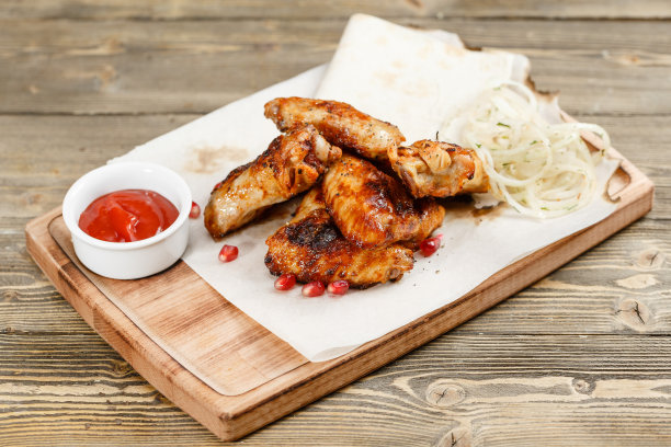 鸡翅烤。放在质朴的桌子上的木板上。烧烤餐厅的菜单，一系列不同肉类的照片图片下载