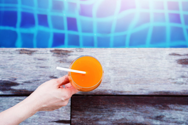 夏天喝。女人放松在她的假期游泳池，顶视图图片下载