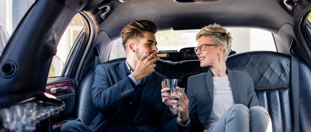 商务人士在豪华轿车里喝酒，全景图片下载