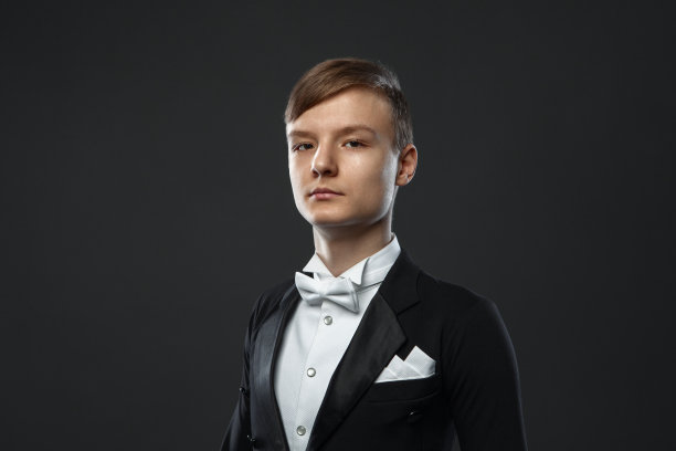 一个穿着西装，背景是黑色的少年图片下载