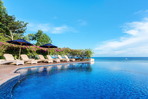 热带度假无限游泳池和躺椅在海边图片下载
