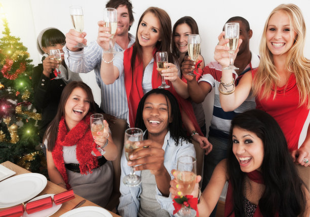快乐的年轻人微笑着，在香槟中举杯庆祝圣诞图片下载