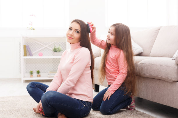 女儿坐在卧室里给妈妈梳头图片下载