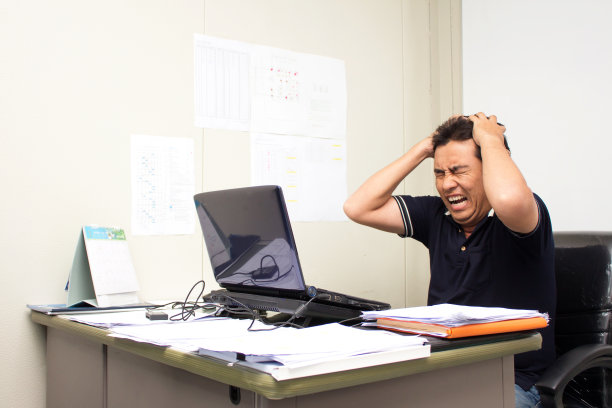 一个在办公室工作的人严重疲劳，头痛图片下载