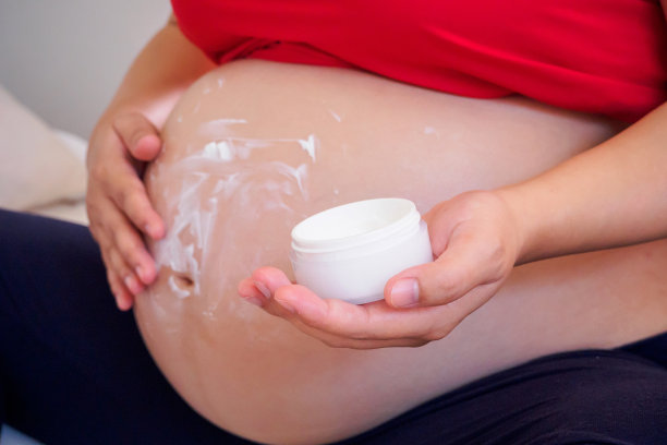孕妇在腹部涂抹妊娠纹霜图片下载