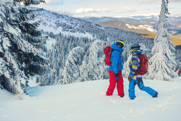 两个背着背包的滑雪者站在山坡上素材图片