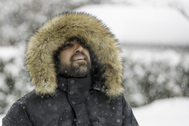 在暴风雪中穿着毛皮大衣的人图片下载