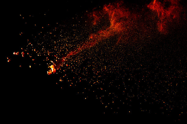 红色橙色粉末爆炸云孤立在黑色背景上。图片下载