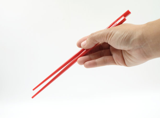 手拿筷子吃在白色的背景图片下载