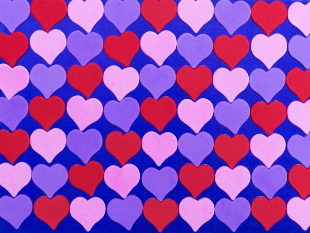 明亮的多色心形图案上的蓝色背景。情人节贺卡，图片为背景。图片下载