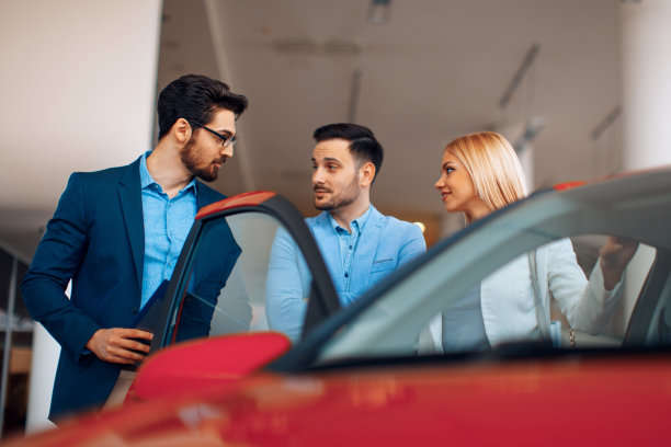 年轻夫妇选择在经销商商店购买新车图片下载