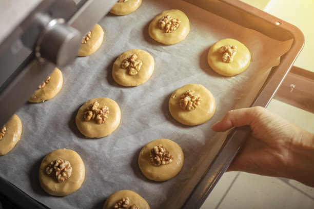 蜂蜜和核桃饼干放在烤盘上，铺上羊皮纸，准备烘烤。家庭烹饪图片下载