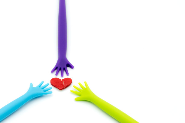 彩色的塑料手举起破碎的心孤立在白色的背景。图片下载
