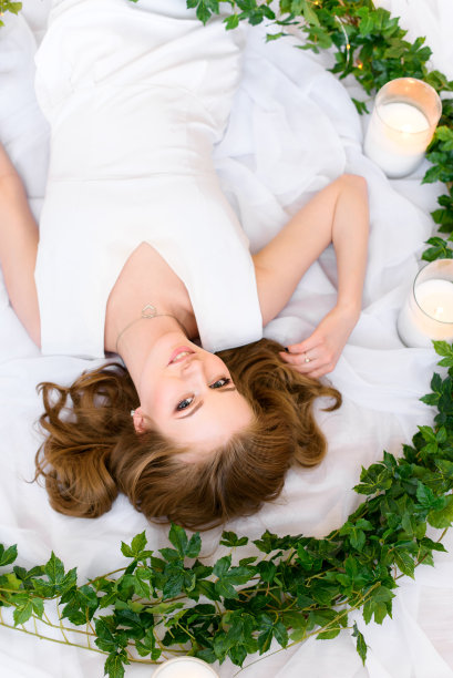 一个可爱的年轻女士倒立在照片上，抚摸着她的头发，温柔地友好地看着镜头，迷人地微笑着图片下载