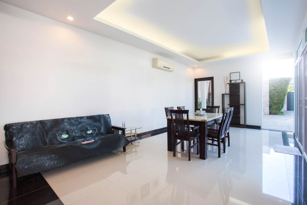 泳池别墅客厅的豪华室内设计。通风明亮的空间，高高的天花板和木制餐桌图片下载