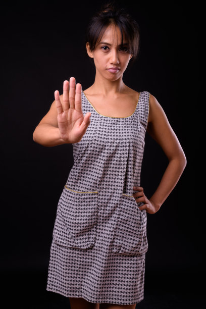 菲律宾妇女在黑色背景下做停止手势的肖像素材图片