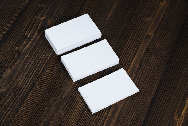 在木制工作台上放置空白名片，并留有空白空间用于添加文本ID。和商标，商业公司的概念。图片下载