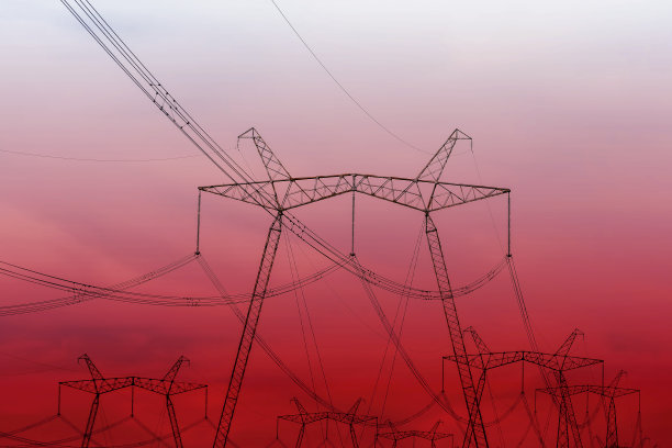 红色天空背景下高压电线的剪影。图片下载