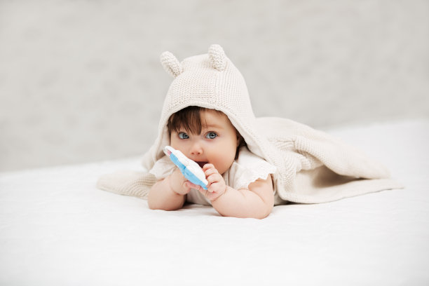 小女孩在家里的毯子上玩玩具的肖像图片下载