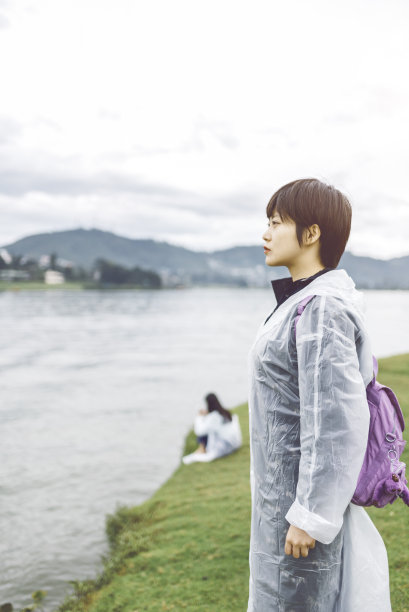 年轻女子穿着雨衣旅行图片下载