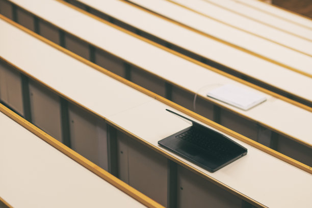 黑色笔记本电脑在大学礼堂的桌子上图片下载