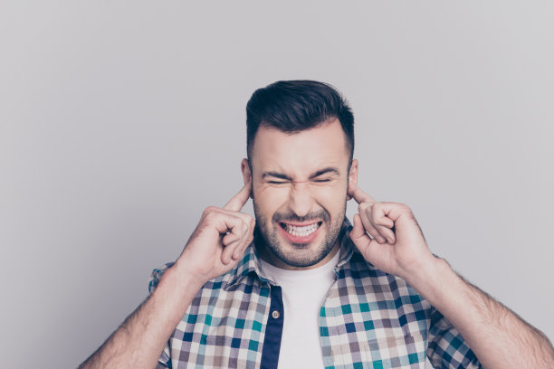 停止说话!肖像疲惫的年轻人，闭上他的眼睛和耳朵的手指，咬紧牙关，站在灰色的背景图片下载