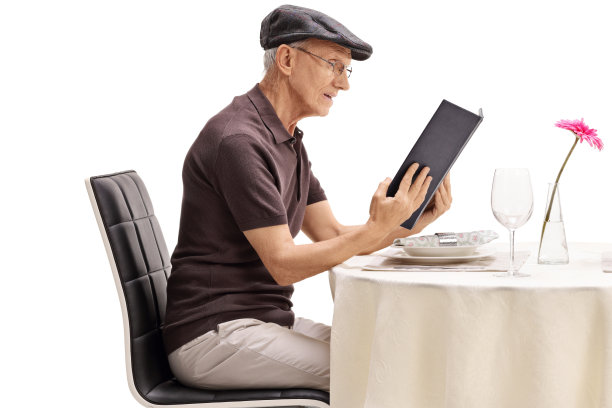 高年级学生坐在餐厅桌子旁看菜单图片下载