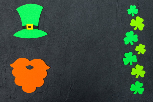 圣帕特里克节主题缤纷横旗。绿色的妖精帽子，胡子和三叶草叶子在黑色的背景。觉得工艺元素。副本的空间。贺卡，贺词横幅图片下载