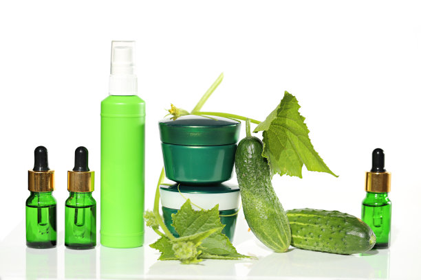 含有黄瓜提取物的化妆品。用黄瓜精华和鲜黄瓜叶在白底反射，滋养面部肌肤。图片下载
