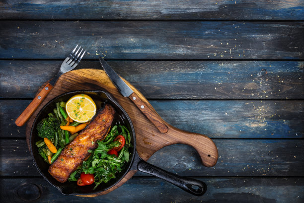 煎锅里的烤三文鱼片，蔬菜，芝麻菜配柠檬。图片下载