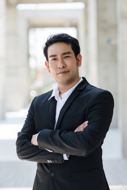 自信的亚洲商人，有着模糊的背景。图片下载