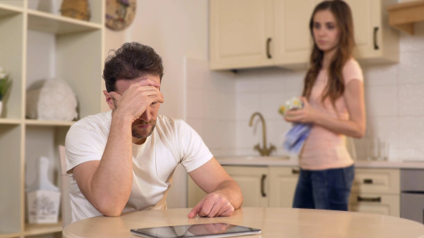 妻子在厨房斥责失业的丈夫，斥责他浪费时间素材图片