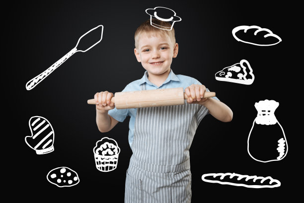 漂亮的男孩假装是一个厨师，拿着一个大擀面杖图片下载