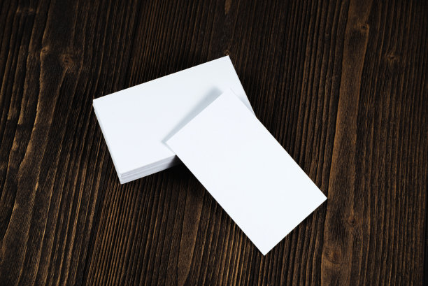 在木制工作台上放置空白名片，并留有空白空间用于添加文本ID。和商标，商业公司的概念。图片下载