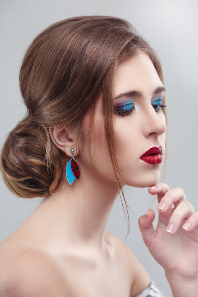 温柔美丽的肖像一个年轻的女孩与明亮的化妆在浅灰色的背景。图片下载