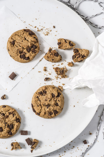 白盘子里放着黑巧克力饼干。图片下载