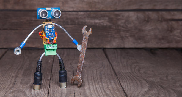 机器人由带扳手的电路板组成，以木头为背景图片下载