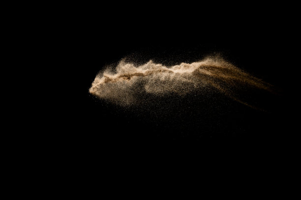 抽象的沙子云。金色的沙子在黑暗的背景下飞溅。黄沙在空中飞舞。沙子爆炸在黑色背景，投掷冻结停止运动。图片下载