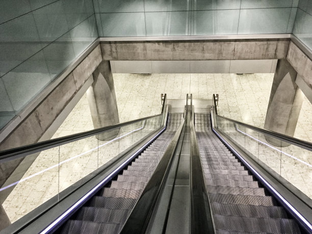 看着扶梯上没有人。在地铁站可以下到下一层的自动扶梯。一个交通枢纽干净、现代的室内设计。添加单色照片滤镜。图片下载
