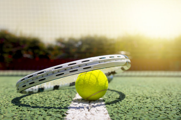 在绿色网球硬地上的网球和球拍图片下载