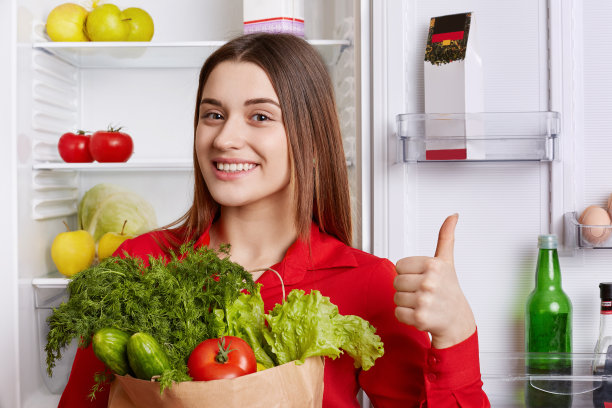 高兴的女人的照片显示ok标志和表示同意，拿着蔬菜，从杂货店出来，心情好有必要的产品制作新鲜的素食沙拉在厨房摆姿势图片下载
