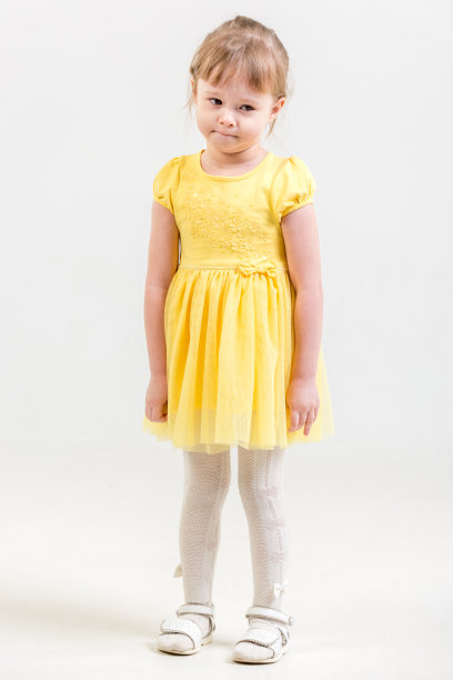 穿着黄色连衣裙的可爱小女孩。全面发展的肖像图片下载