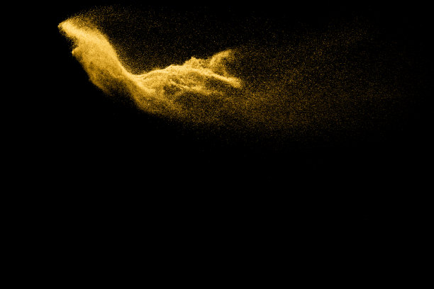 抽象的沙子云。金色的沙子在黑暗的背景下飞溅。黄沙在空中飞舞。沙子爆炸在黑色背景，投掷冻结停止运动。图片下载