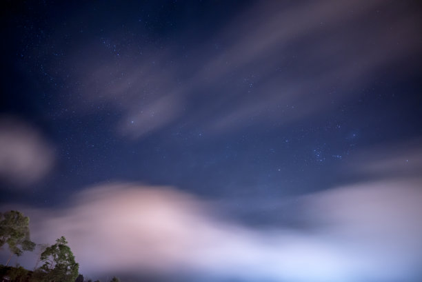 星团在夜空中具有多云多风的天气图片下载