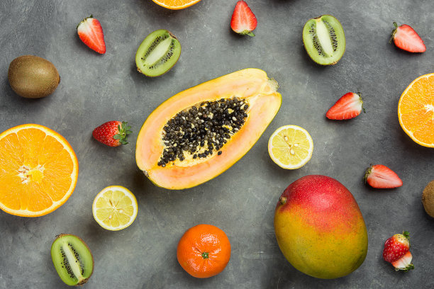 各种不同的热带和季节性夏季水果。木瓜，芒果，橘子，柑橘，橙子，柠檬，草莓，猕猴桃在黑暗的背景。健康生活方式饮食维生素。平躺图片下载