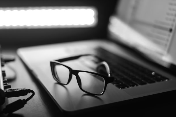 桌上放着眼镜和笔记本电脑图片下载